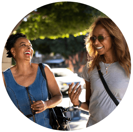 Duas mulheres sorrindo e conversando na rua